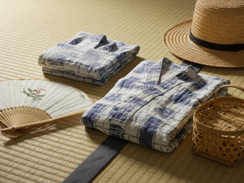 Traditional summer travel essentials including uchiwa fan and lightweight clothing on tatami mat. Traditional summer travel essentials including uchiwa fan and lightweight clothing on tatami mat.