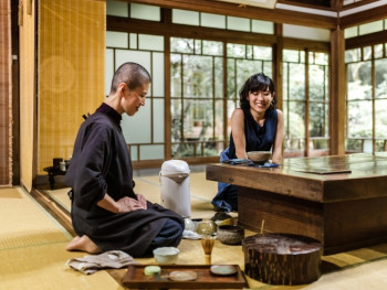 A guide chatting casually with guests in a Kyoto tea house A guide chatting casually with guests in a Kyoto tea house