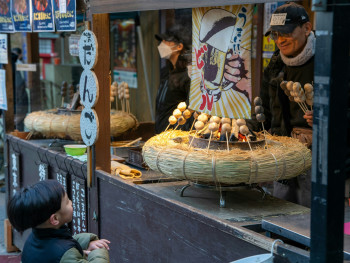 A local sweets vendor handing a traditional wagashi treat to a smiling traveler at a small, tucked-away Kyoto shop Photo by Jong Hyuk Lee on Unsplash A local sweets vendor handing a traditional wagashi treat to a smiling traveler at a small, tucked-away Kyoto shop Photo by Jong Hyuk Lee on Unsplash