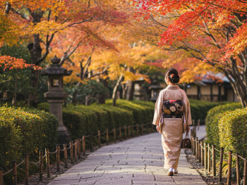 Woman in elegant autumn layers walking on traditional stone path.