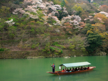 Hozugawa River boat journey with autumn mountains reflected.