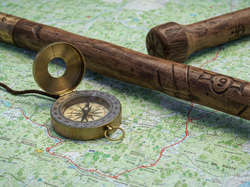 Traditional Japanese compass and walking stick on trail map