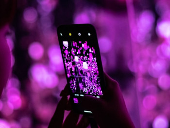 TeamLab Botanical Garden at night with interactive digital flowers blooming around them and colorful light projections on trees TeamLab Botanical Garden at night with interactive digital flowers blooming around them and colorful light projections on trees