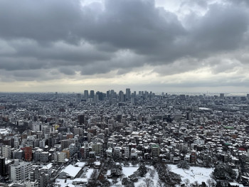A panoramic view of Osaka city in winter from a high vantage point, showing the urban landscape under dramatic winter clouds. A panoramic view of Osaka city in winter from a high vantage point, showing the urban landscape under dramatic winter clouds.