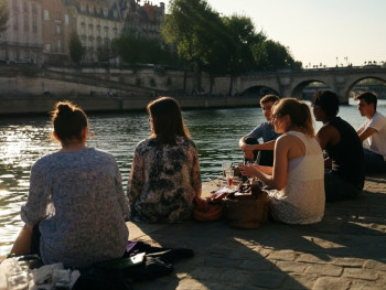 Friends having a picnic by the river Seine Friends having a picnic by the river Seine