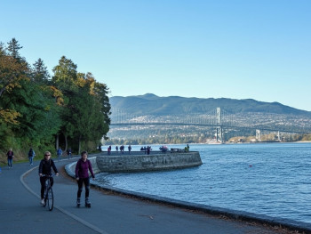 Cyclists riding along the seawall with ocean views. Cyclists riding along the seawall with ocean views.
