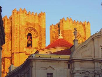 Lisbon Cathedral façade with twin towers and rose window in late afternoon light
