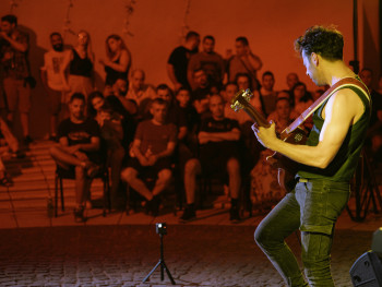 Guitarist and singer performing in a dimly lit tavern