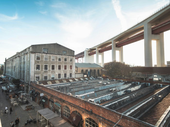 LX Factory walkway with street art, industrial halls, and weekend market stalls