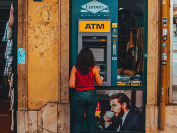ATM on a Lisbon street with a person withdrawing money
