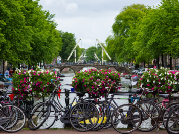 Traditional Amsterdam bikes parked along canal Traditional Amsterdam bikes parked along canal
