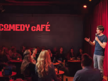 Small comedy club with spotlight on stage and a crowd watching Small comedy club with spotlight on stage and a crowd watching