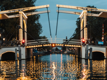 Magere Brug at dusk, calm water, people crossing Magere Brug at dusk, calm water, people crossing