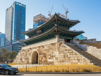 Traditional Korean palace gate with modern Seoul skyline in background