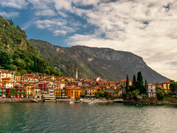 Quiet lake Como town with boats and mountains in the background Quiet lake Como town with boats and mountains in the background