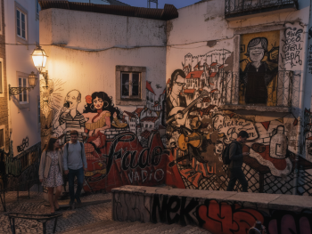 Mouraria backstreet, fado mural, evening cafe lights