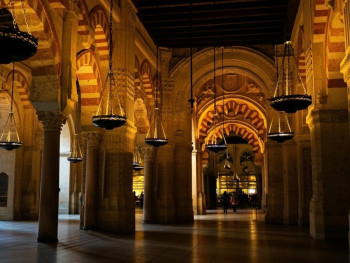 Gothic Quarter stone archway lit by warm streetlights at blue hour