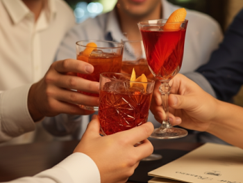 Locals at Bar Basso holding classic Negroni Sbagliato cocktails
