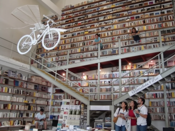 Bookshelves filling the space at Ler Devagar, with a flying bicycle overhead Bookshelves filling the space at Ler Devagar, with a flying bicycle overhead