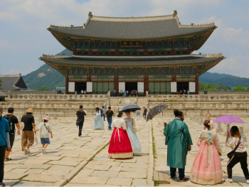 People at Gyeongbokgung Palace in traditional clothing and onlookers enjoying the view People at Gyeongbokgung Palace in traditional clothing and onlookers enjoying the view