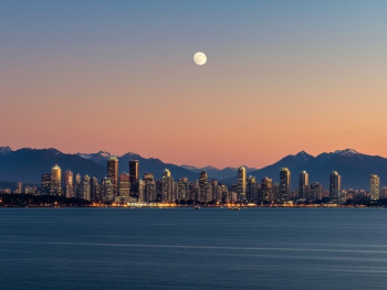 Vancouver skyline transitioning from golden hour to night with mountains and ocean Vancouver skyline transitioning from golden hour to night with mountains and ocean