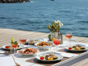 Waterfront table with menu and wine on Sorrento’s flat marina boardwalk