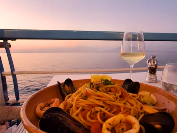 Seaside deck at Bagni Sant'Anna with seafood and sunset views over the bay Seaside deck at Bagni Sant'Anna with seafood and sunset views over the bay