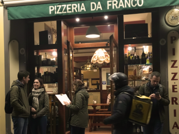 Outside Pizzeria Da Franco with communal benches and people waiting for a seat Outside Pizzeria Da Franco with communal benches and people waiting for a seat