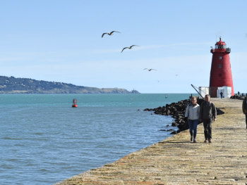 Red Poolbeg Lighthouse at the end of stone wall stretching into Dublin Bay Red Poolbeg Lighthouse at the end of stone wall stretching into Dublin Bay