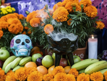 Copal incense smoke rising from the altar with marigold petals Copal incense smoke rising from the altar with marigold petals