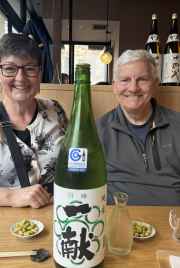 Two people sitting at a wooden table in a Japanese restaurant.
