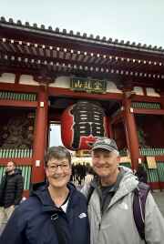 Visitors posing near the large red lantern of Kaminarimon Gate, Tokyo.