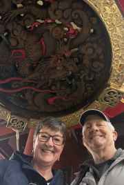Two people standing under a large red lantern at Senso-ji Temple, Tokyo.
