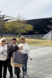 A happy trio poses by an impressive ship in Nagasaki.