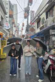 Enjoying a rainy day adventure in a vibrant Seoul neighborhood.