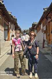 Strolling through Seoul's historic hanok village under a bright blue sky.