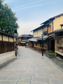 A peaceful residential street in Kyoto with traditional wooden houses alongside modern buildings under soft daylight. Image by Shirley Wang on Unsplash.