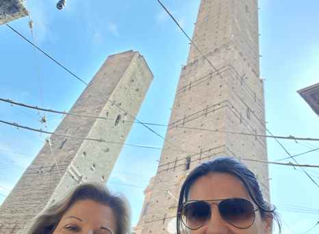 Towering Giants: A Smiling Moment Beneath Bologna's Skies