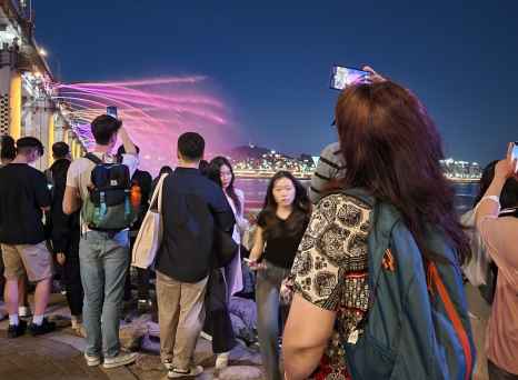 People watch the Banpo Bridge Rainbow Fountain show in Seoul at night.