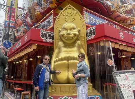 A colorful storefront in Osaka featuring a prominent golden statue.