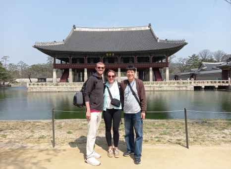 Three people standing in front of Gyeonghoeru Pavilion, Seoul, South Korea.