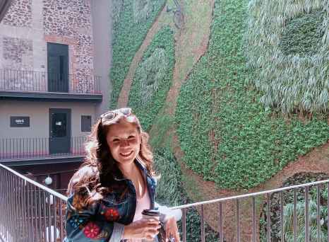 Person photographed on balcony overlooking interior garden at Downtown Mexico.