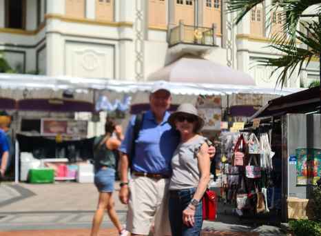 Sultan Mosque's golden dome with people passing by in Singapore.