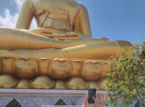 Tourists photographing the huge Buddha statue at Wat Muang.