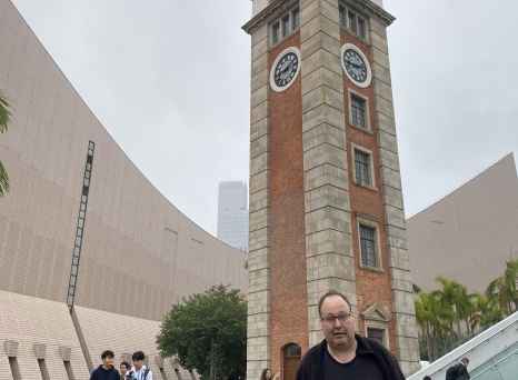 Historical clock tower at Tsim Sha Tsui, Hong Kong alongside visitors.