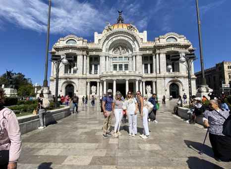 Visitors standing near Palacio de Bellas Artes entrance in Mexico City.
