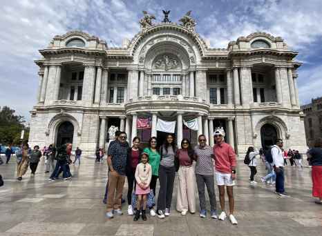 Group of people standing in front of Palacio de Bellas Artes, Mexico City.