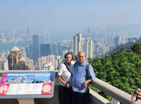 Visitors at Hong Kong's Victoria Peak, capturing the city and harbor on a clear day.