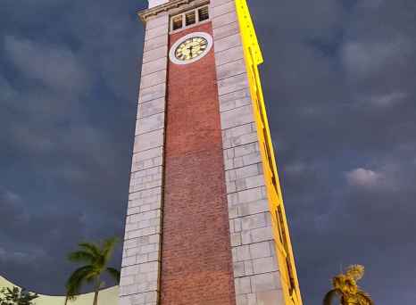 Clock tower at night with clouds in the background.