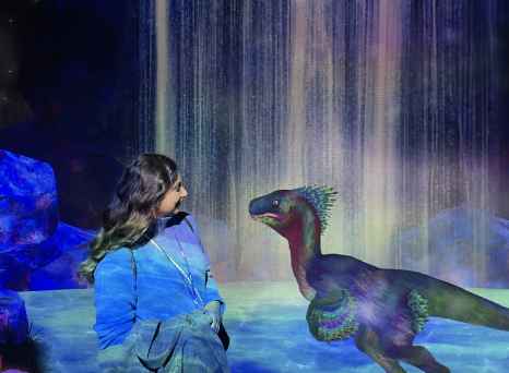 Woman looking at digital dinosaur in an interactive exhibit.
